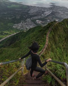 Femme au sommet d'un escalier surplombant la forêt et la ville